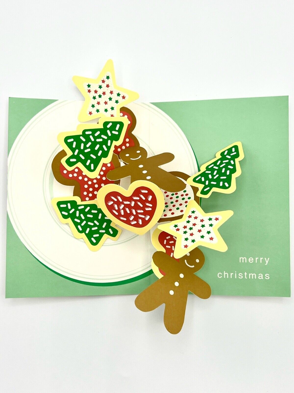 A set of three-dimensional pop-up greeting cards featuring a Christmas cookie design with green envelopes and the text 'Merry Christmas' on the inside.