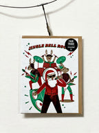 Christmas-themed greeting card with illustration of Santa and reindeer, featuring a Fair Trade recycled label.