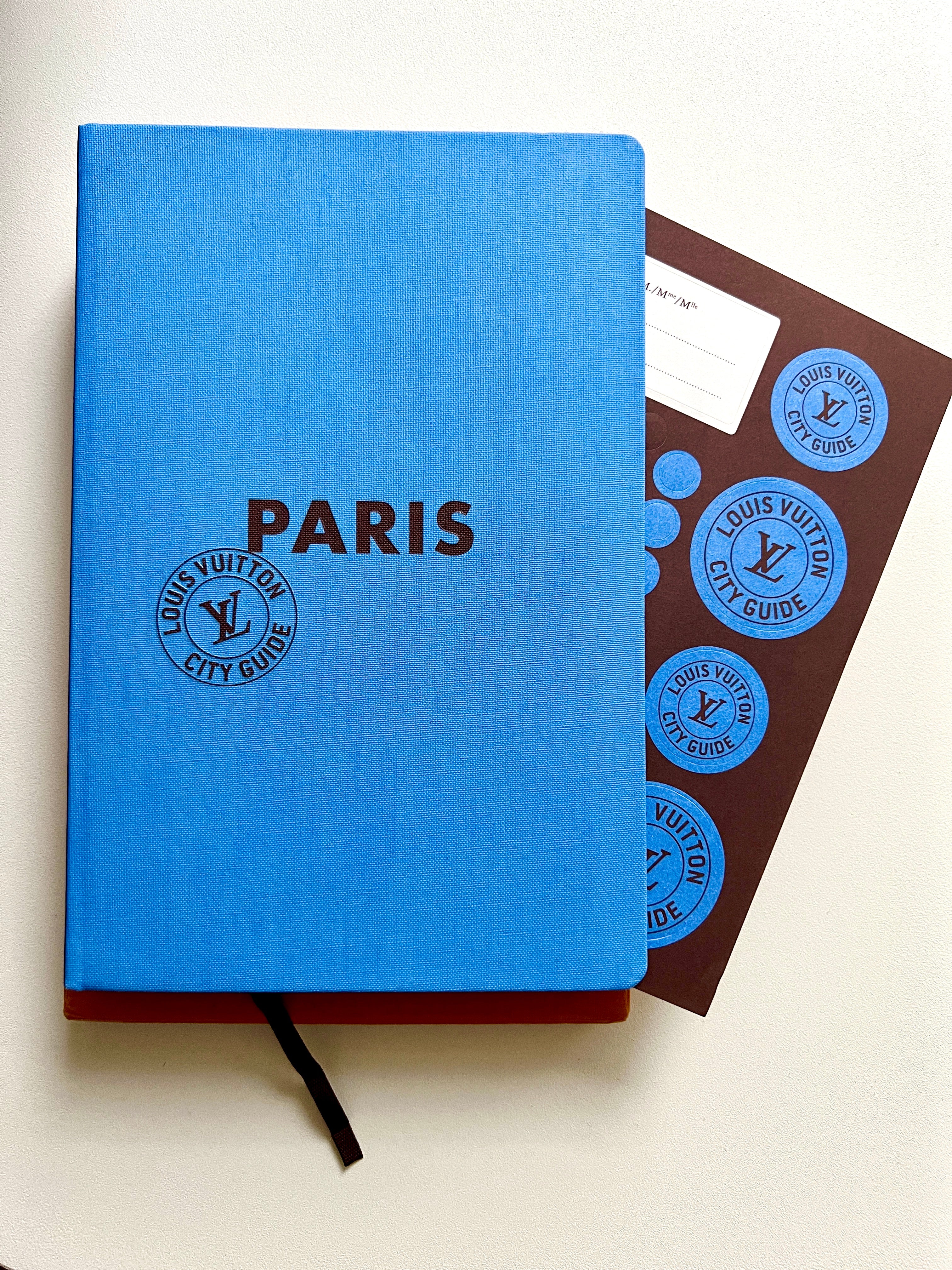 Blue notebook with 'PARIS' and Louis Vuitton logo on a white background