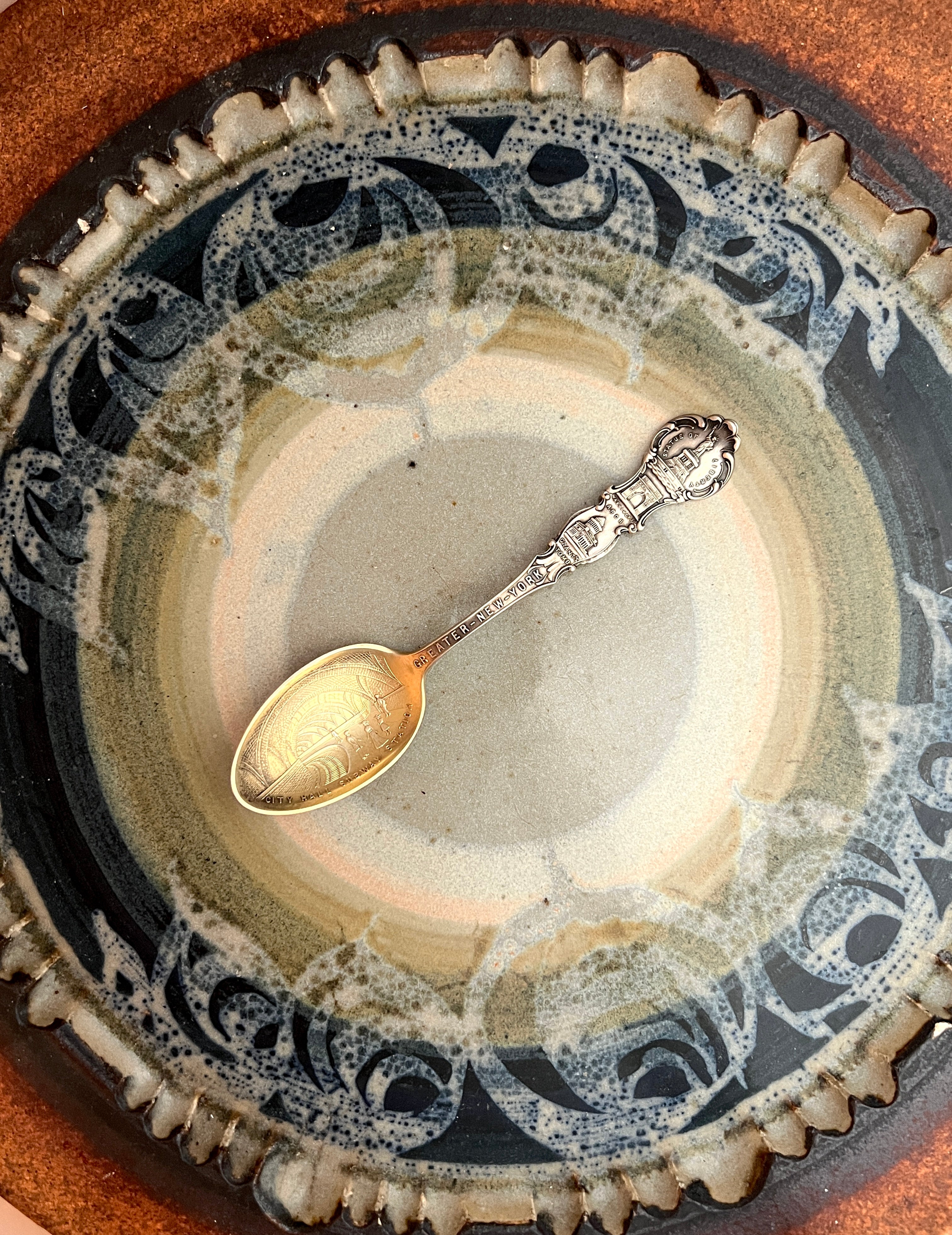 silver spoon with Gilt Wash  on a decorative ceramic surface