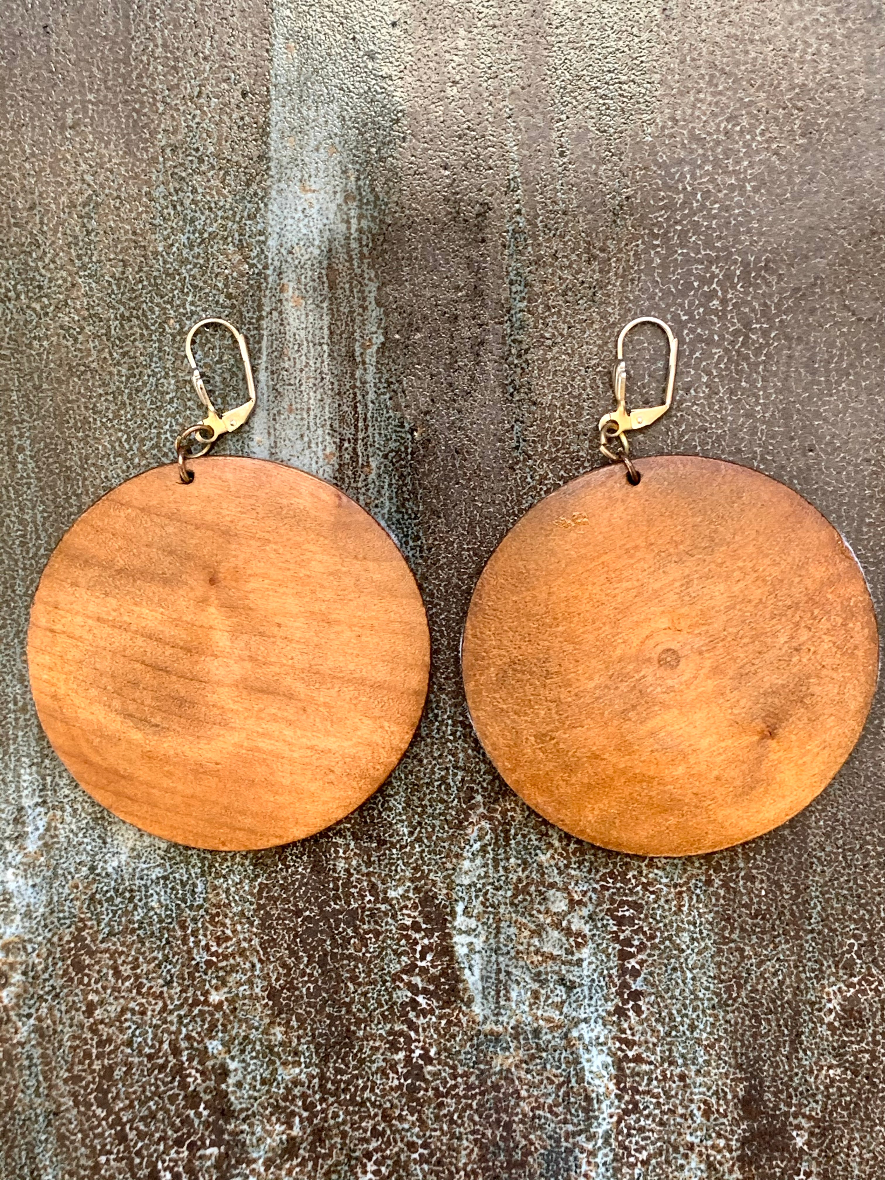 Wooden round earrings on a textured surface