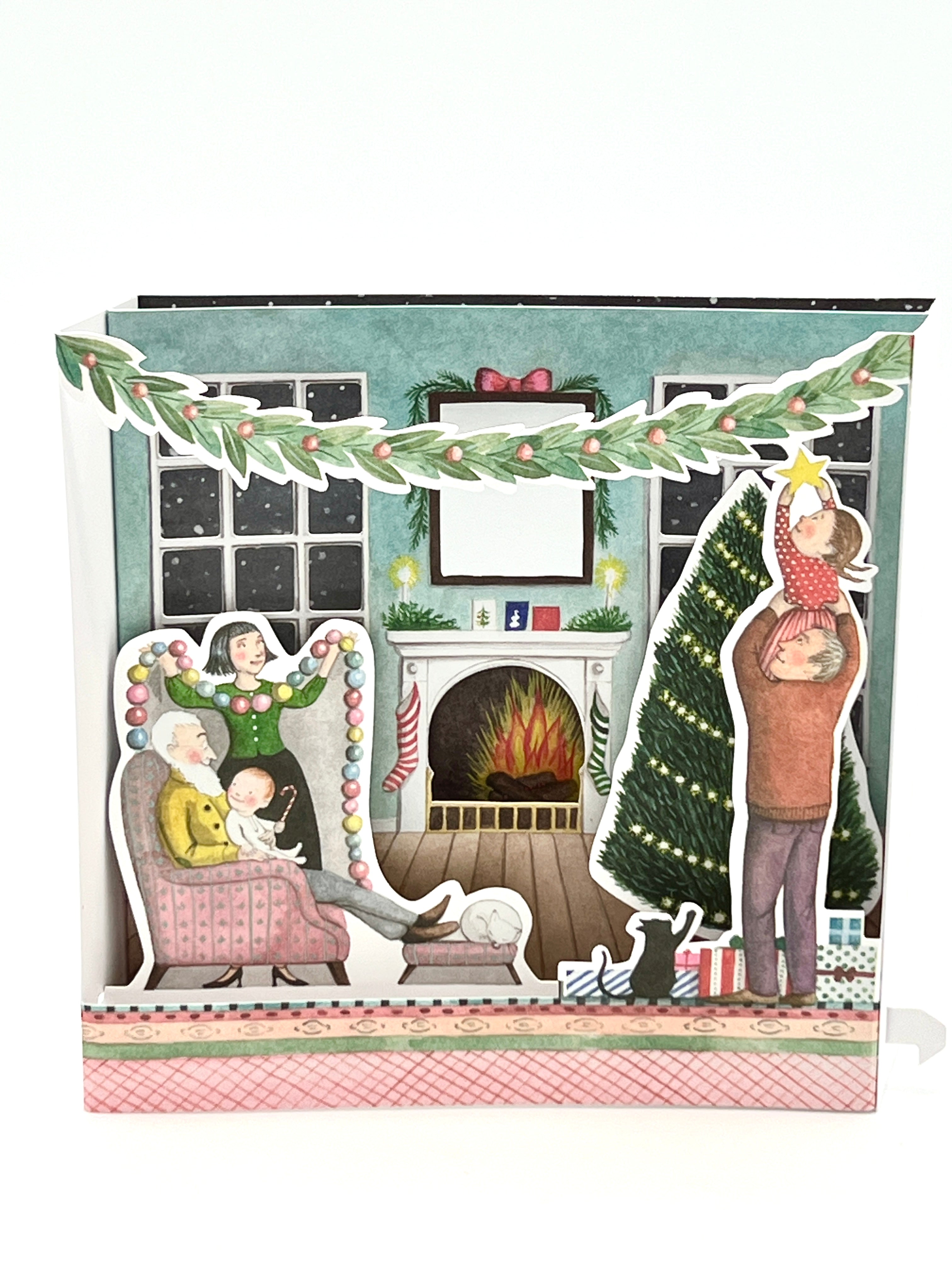 A 3D holiday greeting card depicting a warm Christmas scene with a decorated tree and gifts, a fireplace, and people enjoying the holiday. The card has a 'Merry Christmas' greeting on the back.